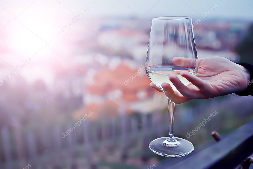 male hand holding glass of white wine 