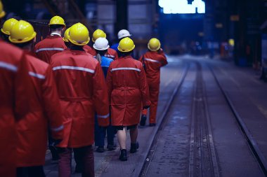 Grup işçi fabrikada kask içinde arkadan görüntülemek