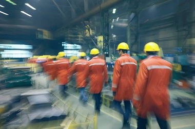 Grup işçi fabrikada kask içinde arkadan görüntülemek
