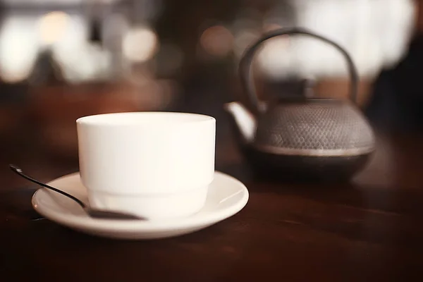 English tea in cafe, cup and kettle with five o'clock tea