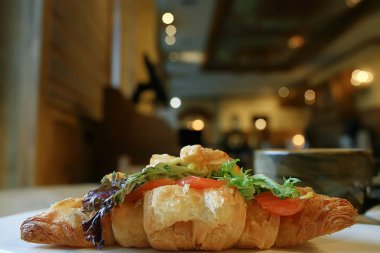 bir restoranda kahvaltı için somon ve salata ile bir Fransız Kafe/kruvasandan kahvaltı