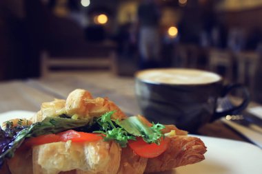 bir restoranda kahvaltı için somon ve salata ile bir Fransız Kafe/kruvasandan kahvaltı