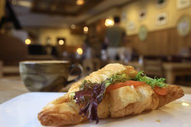 bir restoranda kahvaltı için somon ve salata ile bir Fransız Kafe/kruvasandan kahvaltı