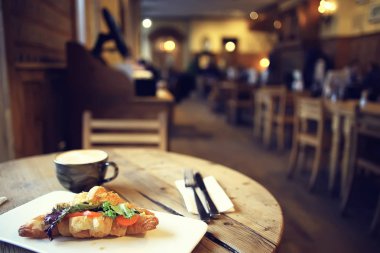 bir restoranda kahvaltı için somon ve salata ile bir Fransız Kafe/kruvasandan kahvaltı