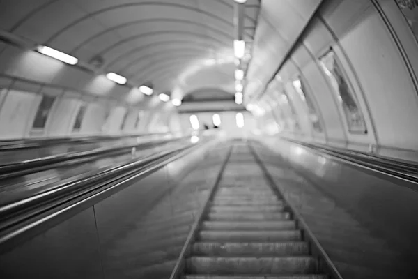 blurred background metro escalator / light blue background movement city infrastructure subway