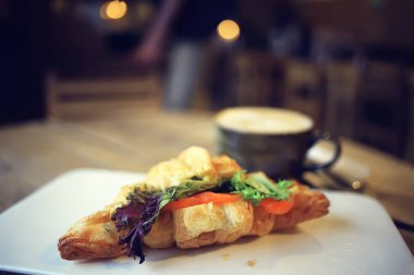 bir restoranda kahvaltı için somon ve salata ile bir Fransız Kafe/kruvasandan kahvaltı
