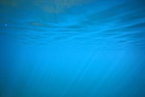 海の水青い背景水中光線太陽 抽象的な青の背景自然の水 — ストック写真