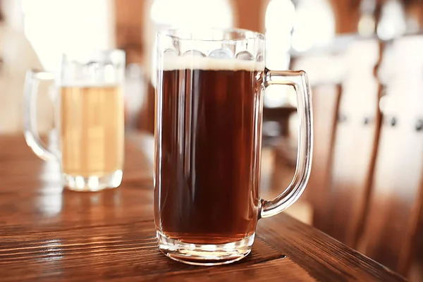 two beer mugs in a Czech beer restaurant / light and dark beer in large mugs traditional Prague pub