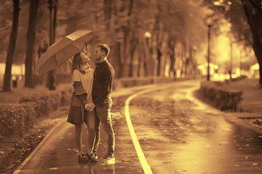 autumn landscape in the park girl with a red umbrella / concept autumn weather raining, a young woman under an umbrella