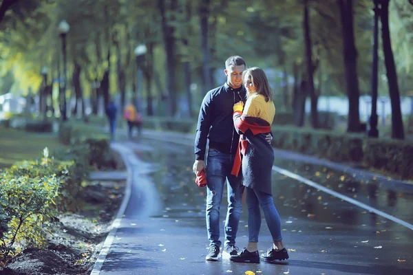 autumn landscape with people in the park / gerfrend and boyfriend hug in autumn park, fall view person