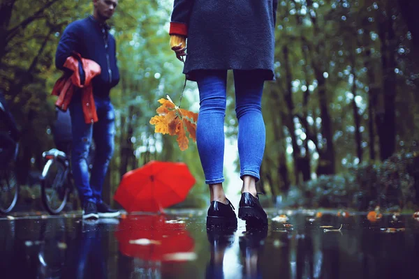 autumn landscape in the park girl with a red umbrella / concept autumn weather raining, a young woman under an umbrella