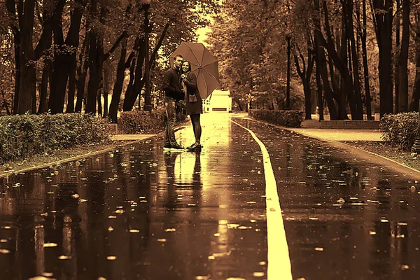 傘の下で二人の人 男と女が傘を持って公園を歩いていて 雨の秋を歩いている 秋の傘 — ストック写真