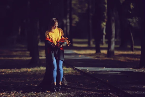 秋の眺め 一人の女の子が公園の中を歩く 黄色い葉 秋の公園 寂しい女の子が秋の公園で休んでいる — ストック写真