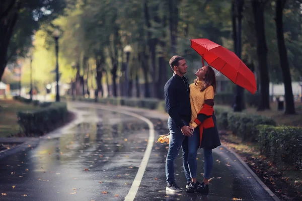 两个人在伞下 一男一女拿着伞走在公园里 在雨中走在雨中 一把秋伞 — 图库照片