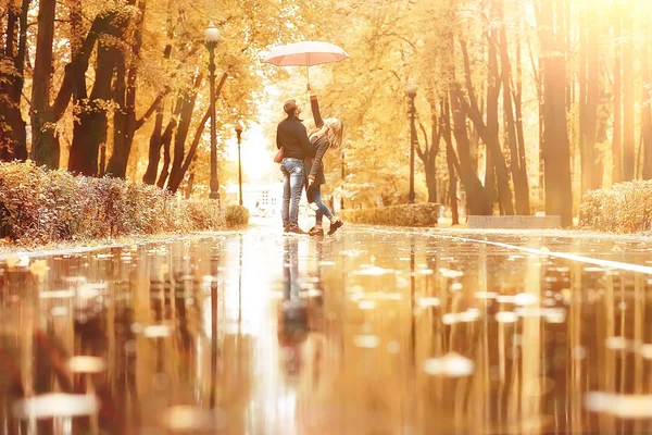 傘の下で二人の人 男と女が傘を持って公園を歩いていて 雨の秋を歩いている 秋の傘 — ストック写真
