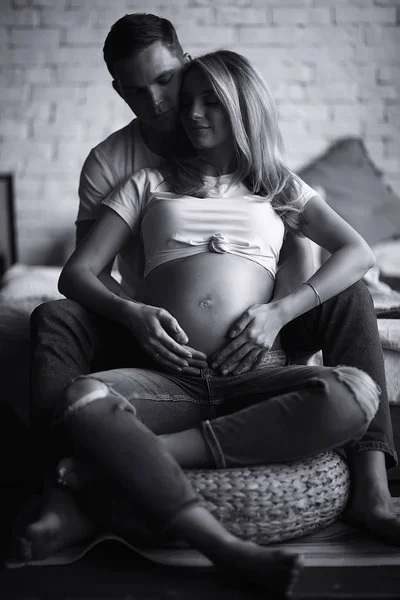 pregnancy concept childbirth and love / man and woman, big belly, hands in the shape of a heart, symbol of pregnancy and love