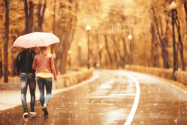 秋の公園の雨 若い25歳のカップル男と女は湿った雨の中で傘の下を歩く 10月の恋人を歩く — ストック写真