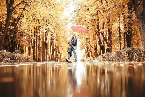 两个人在伞下 一男一女拿着伞走在公园里 在雨中走在雨中 一把秋伞 — 图库照片