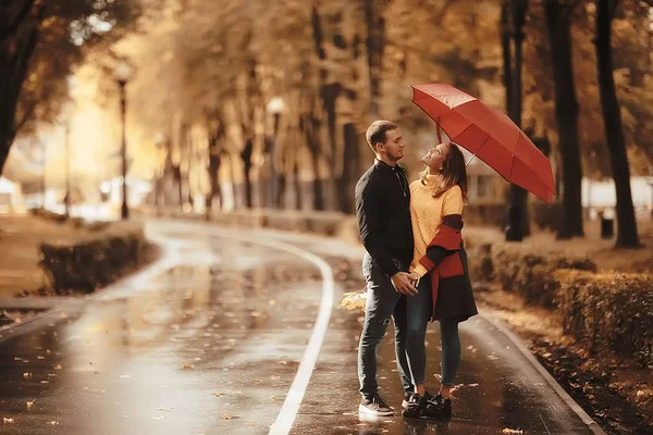 两个人在伞下 一男一女拿着伞走在公园里 在雨中走在雨中 一把秋伞 — 图库照片