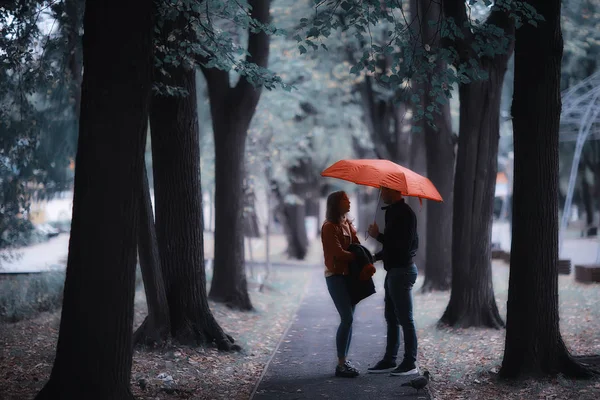两个人在伞下 一男一女拿着伞走在公园里 在雨中走在雨中 一把秋伞 — 图库照片
