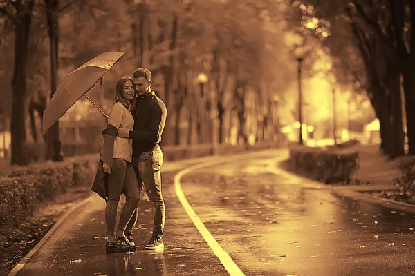 autumn landscape in the park girl with a red umbrella / concept autumn weather raining, a young woman under an umbrella