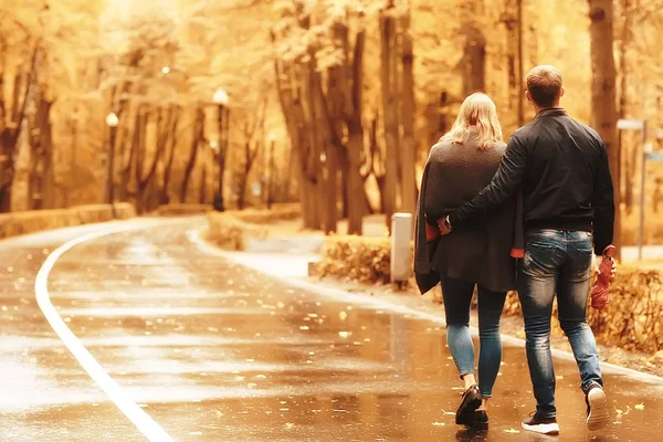 秋の公園の太陽光線 愛のカップル 若い男性と女性が歩いている 日当たりの良い公園の秋の眺め 太陽の光 暖かい秋の背景 — ストック写真