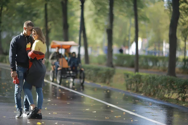 autumn landscape with people in the park / gerfrend and boyfriend hug in autumn park, fall view person