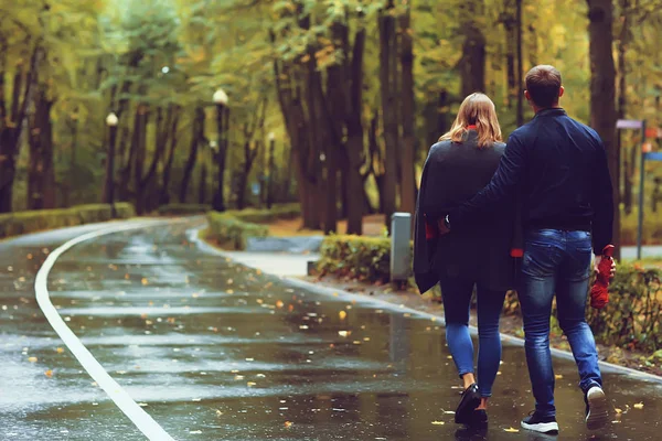 autumn landscape with people in the park / gerfrend and boyfriend hug in autumn park, fall view person