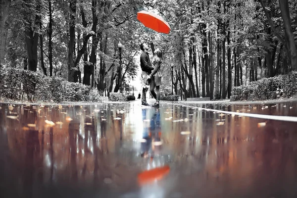 autumn landscape in the park girl with a red umbrella / concept autumn weather raining, a young woman under an umbrella