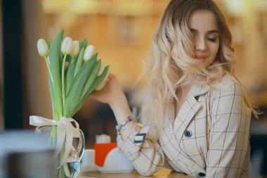 bir kafede çiçekler bir buket ile kız/güzel vitrin, diyet, mutluluk, ruh hali