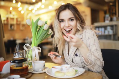 bir masada bir kafede oturan kız/güzel genç model çiçekler bir demet ile poz, mutlu yetişkin kız arkadaşı