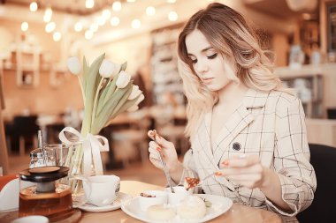 bir masada bir kafede oturan kız/güzel genç model çiçekler bir demet ile poz, mutlu yetişkin kız arkadaşı