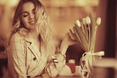 bir masada bir kafede oturan kız/güzel genç model çiçekler bir demet ile poz, mutlu yetişkin kız arkadaşı