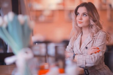 bir masada bir kafede oturan kız/güzel genç model çiçekler bir demet ile poz, mutlu yetişkin kız arkadaşı