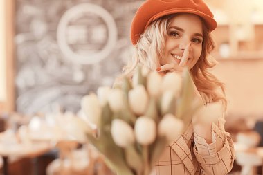 bir masada bir kafede oturan kız/güzel genç model çiçekler bir demet ile poz, mutlu yetişkin kız arkadaşı