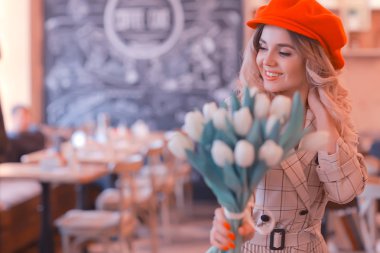 bir masada bir kafede oturan kız/güzel genç model çiçekler bir demet ile poz, mutlu yetişkin kız arkadaşı