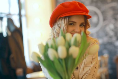 bir masada bir kafede oturan kız/güzel genç model çiçekler bir demet ile poz, mutlu yetişkin kız arkadaşı