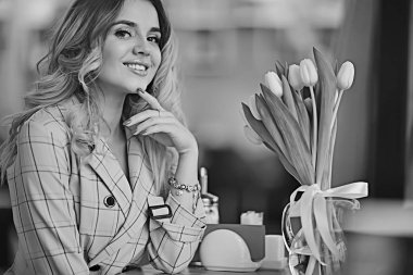 bir masada bir kafede oturan kız/güzel genç model çiçekler bir demet ile poz, mutlu yetişkin kız arkadaşı