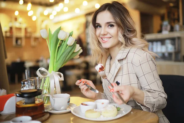 bir masada bir kafede oturan kız/güzel genç model çiçekler bir demet ile poz, mutlu yetişkin kız arkadaşı