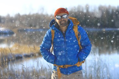 Sırt çantası / doğa manzaralı kış manzarası adamı Kanada 'da karlı bir havada ekipmanla yürüyüşe çıkan bir adam.
