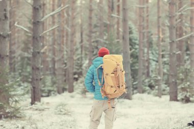 Kış manzarası sırt çantalı gezgin adam / gezgin ormandaki kışlık giysiler, Avrupa dağlarında seyahat, İsviçre kışı