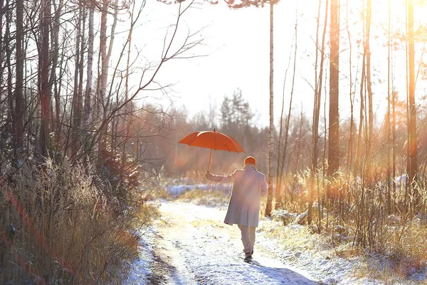 winter walk with an umbrella / man in a coat with an umbrella, walk against the backdrop of the winter landscape, winter view