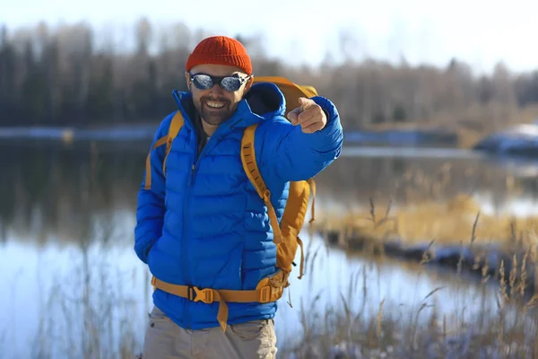 Kış manzarası sırt çantalı gezgin adam / gezgin ormandaki kışlık giysiler, Avrupa dağlarında seyahat, İsviçre kışı