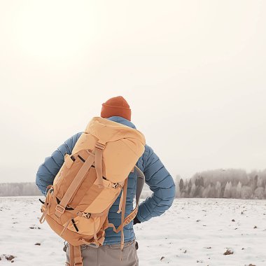 Norveç'te kışın sırt çantası yürüyüş ile turist arka görünümü / Norveç kış manzara sırt çantası taşıyan bir adam.