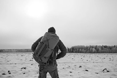 arkadan turist görünümü / bir sırt çantası ile bir adam giden görünümü, kış ormanı geçer