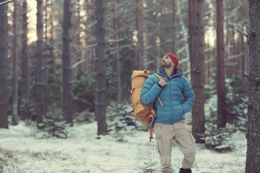 Kış manzarası sırt çantalı gezgin adam / gezgin ormandaki kışlık giysiler, Avrupa dağlarında seyahat, İsviçre kışı