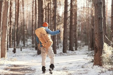 Kış manzarası sırt çantalı gezgin adam / gezgin ormandaki kışlık giysiler, Avrupa dağlarında seyahat, İsviçre kışı