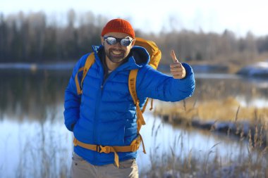 Kış manzarası sırt çantalı gezgin adam / gezgin ormandaki kışlık giysiler, Avrupa dağlarında seyahat, İsviçre kışı
