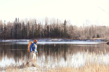 nehir / turist adam tarafından bir sırt çantası ile gezgin kuzey yürüyüşü, kış gezisi