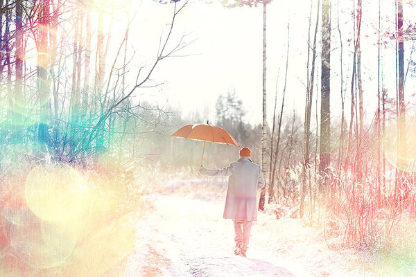 Winter walk with an umbrella / man in a coat with an umbrella, walk against the backdrop of the winter landscape, winter view